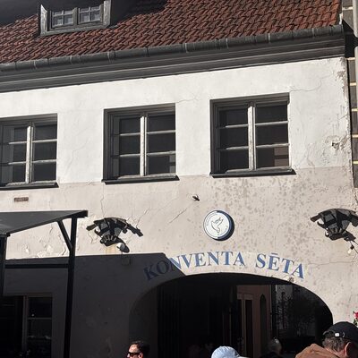 The dove emblem and the dragon-shaped wrought-iron sconces above the Konventa Sēta entrance, Riga, Latvia