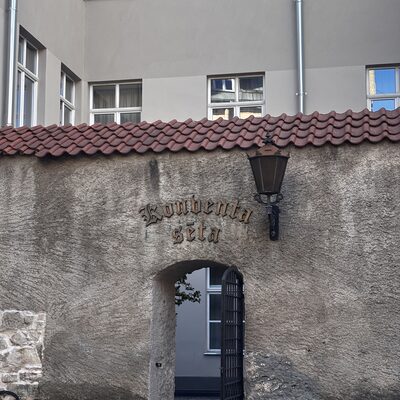 Close-up of the gothic-script &lsquo;Konventa sēta&rsquo; sign and lantern on the back gate, Riga, Latvia