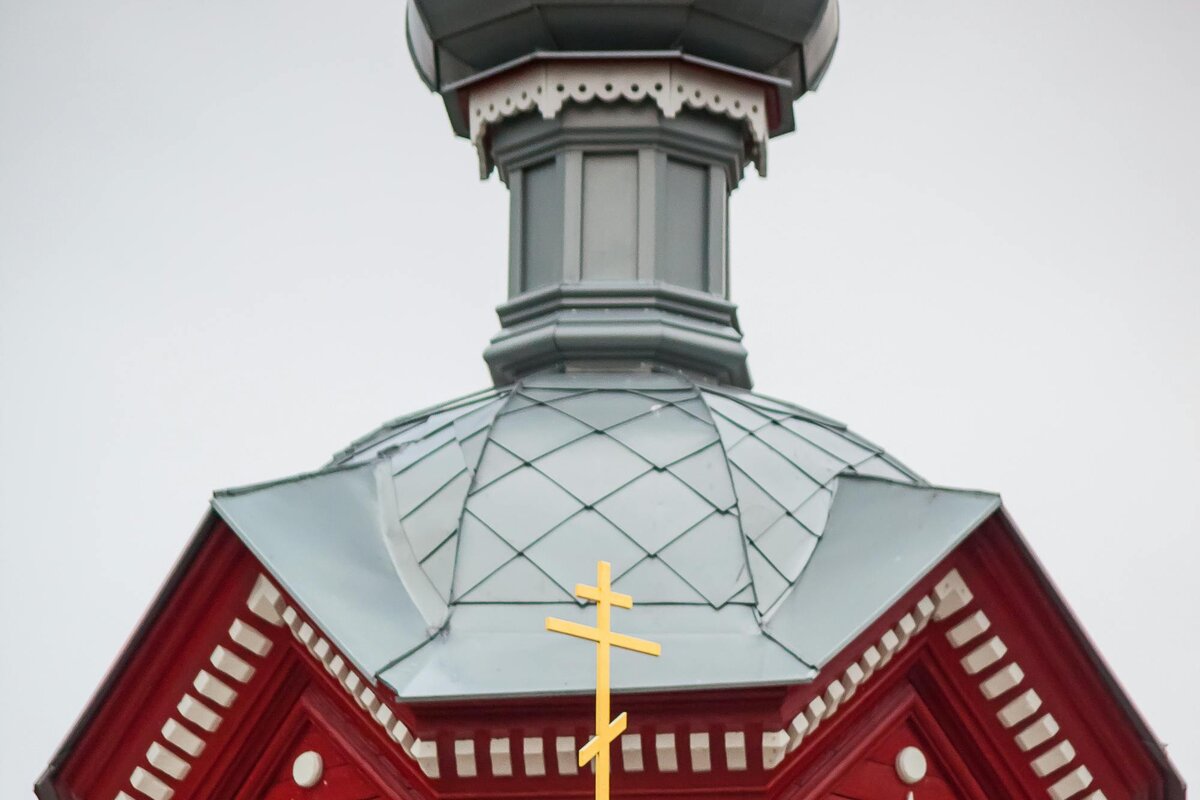 A wooden Orthodox church with onion dome and the eight-pointed three-bar Orthodox cross — Latvia.