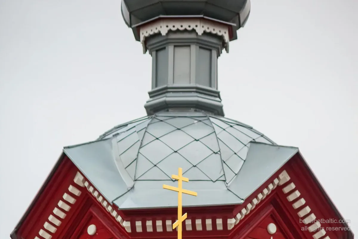 A wooden Orthodox church with onion dome and the eight-pointed three-bar Orthodox cross — Latvia.