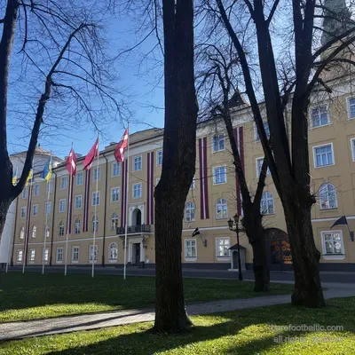 Pils laukums in spring with castle flags between bare trees, Riga, Latvia