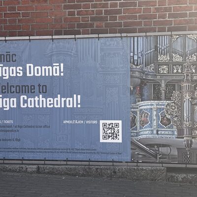The welcome banner outside Riga Cathedral showing the Walcker organ, Latvia