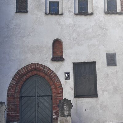 The arched brick doorway of number 17 with a small carved guardian stone, Riga, Latvia