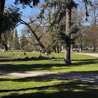 People sitting on the grass in Vērmanes dārzs in spring, Riga, Latvia