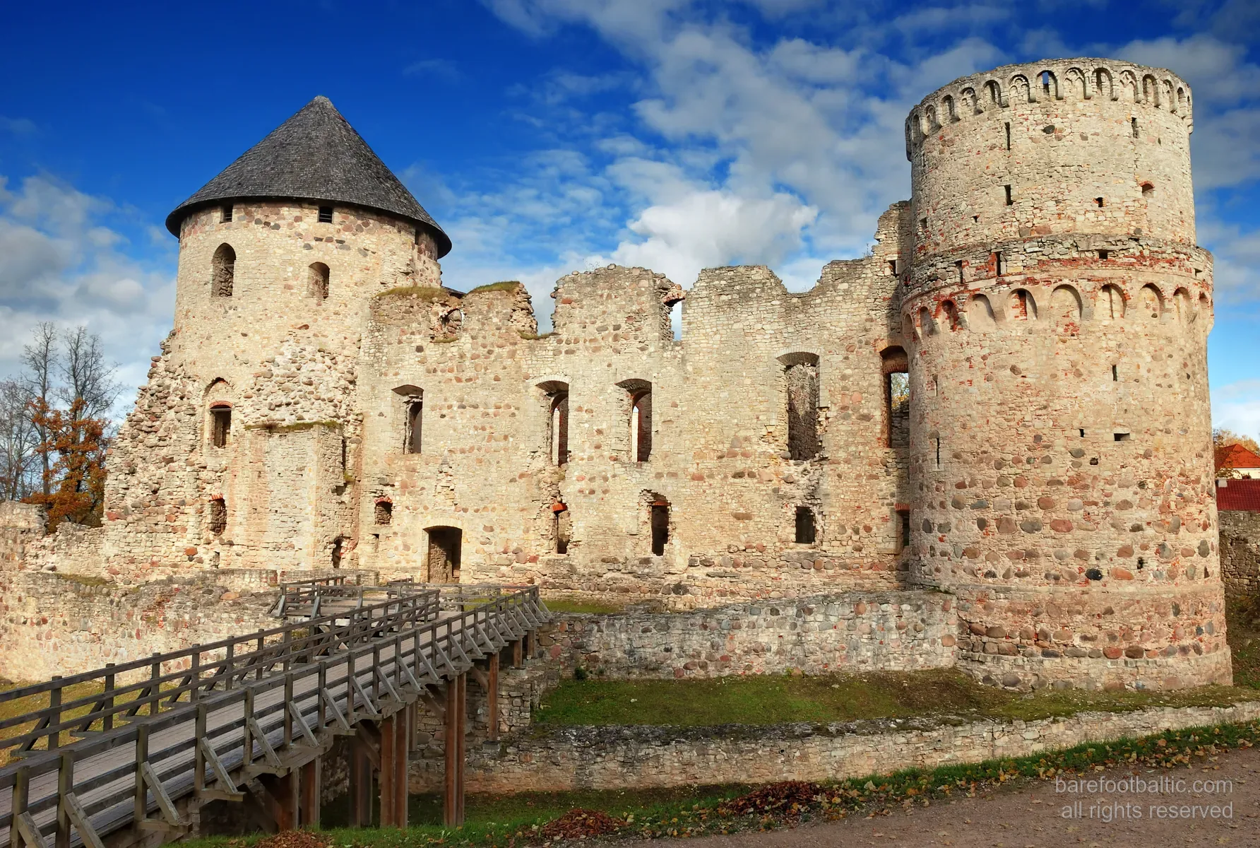 Exterior of the medieval Cēsis Castle ruins, red brick walls in autumn light, Latvia