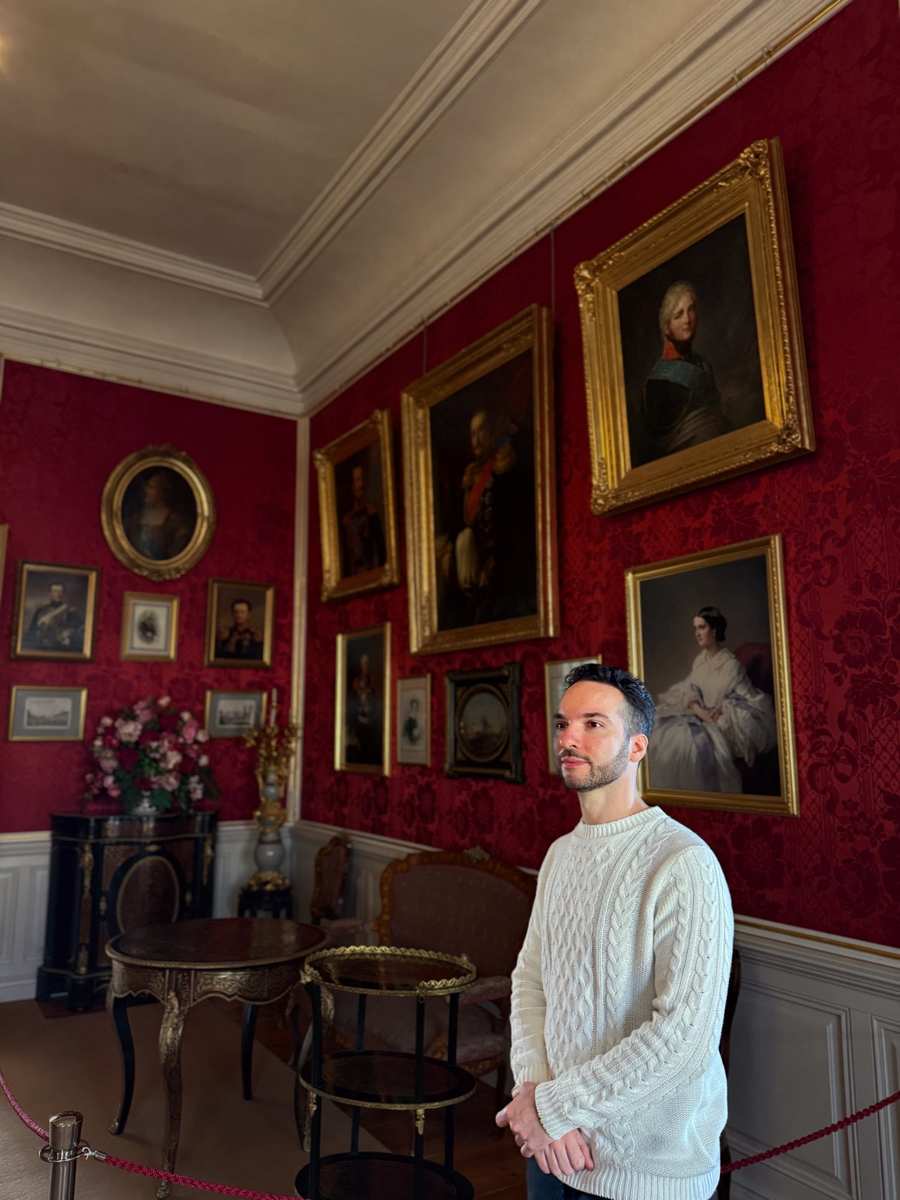Rundāle Palace Red Room — crimson walls lined with gold-framed royal portraits