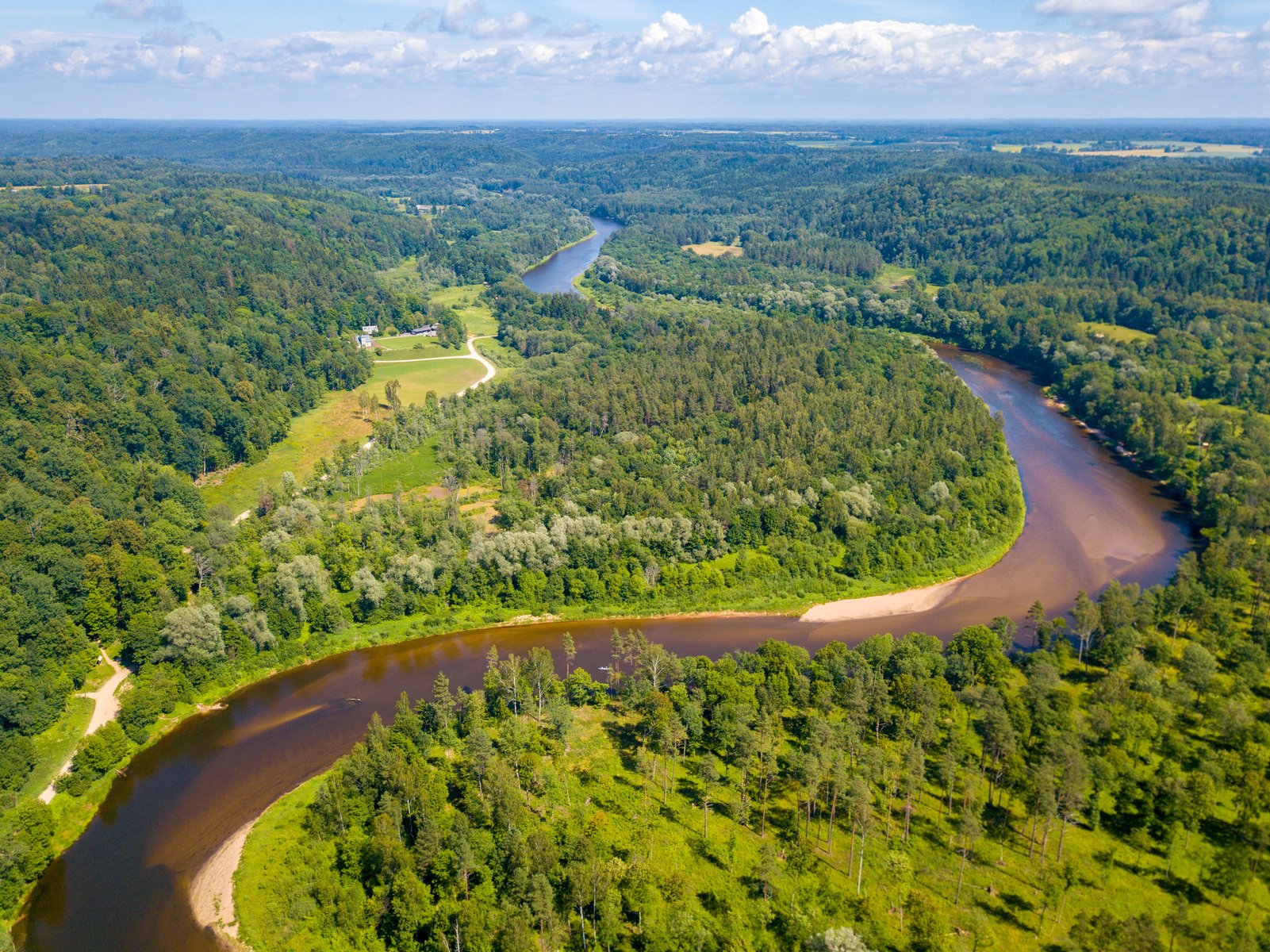 Aerial view of the Gauja river bending through the forested valley near Sigulda