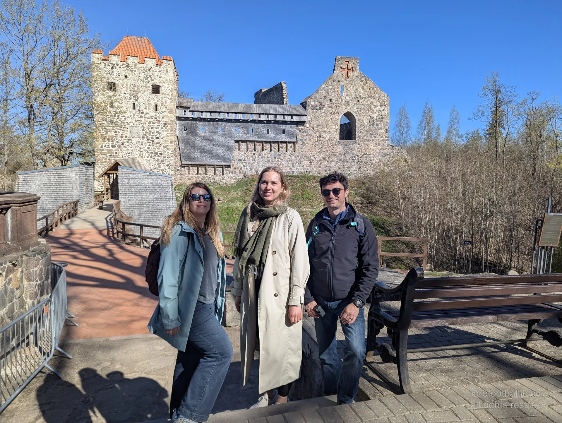Barefoot Baltic guests posing in front of the medieval castle ruins at Sigulda
